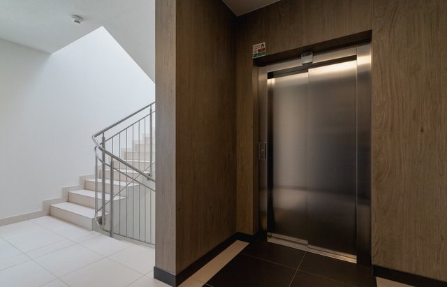 Lift door in the stairwell, with the staircase next to it